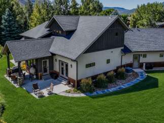 Experience luxury mountain living in this stunning home, featuring a spacious covered patio perfect for outdoor entertaining with a grill and dining set.