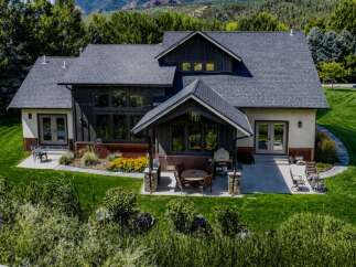 Experience luxury living in this stunning modern home, featuring a spacious patio with outdoor dining and a fire pit perfect for entertaining.