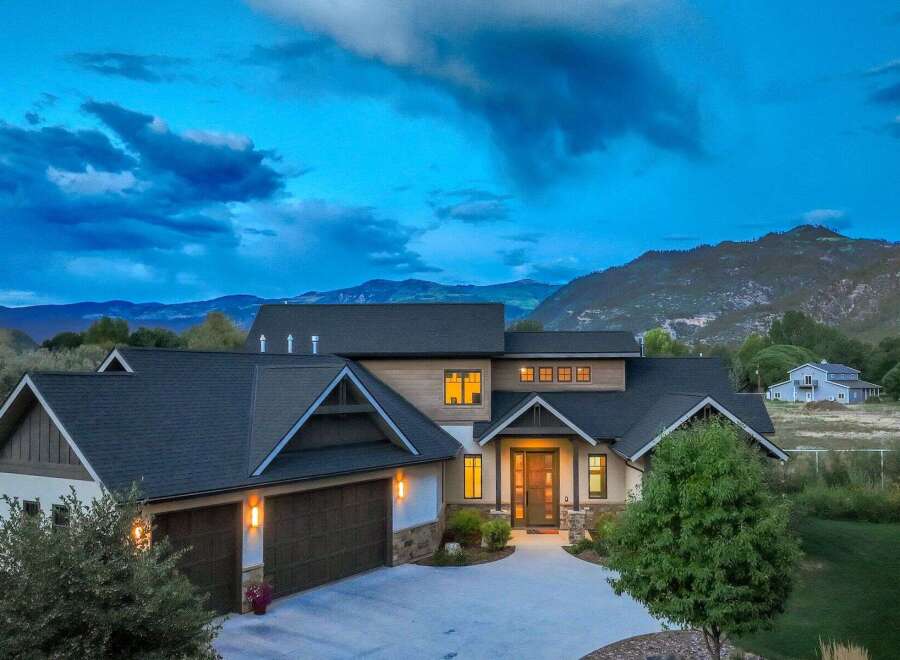Experience luxury mountain living in this stunning modern home, nestled against a backdrop of majestic peaks.