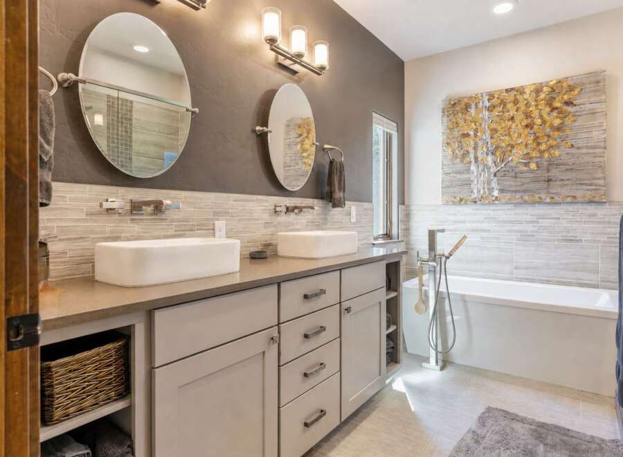 Experience luxury in this modern bathroom featuring a spacious double vanity with vessel sinks and sleek chrome fixtures.