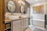 Experience luxury in this modern bathroom featuring a spacious double vanity with vessel sinks and sleek chrome fixtures.