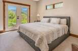 Experience serene living in this beautifully appointed bedroom, featuring a plush king-sized bed with a tufted headboard and a cozy quilted comforter.