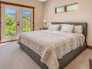 Experience serene living in this beautifully appointed bedroom, featuring a plush king-sized bed with a tufted headboard and a cozy quilted comforter.