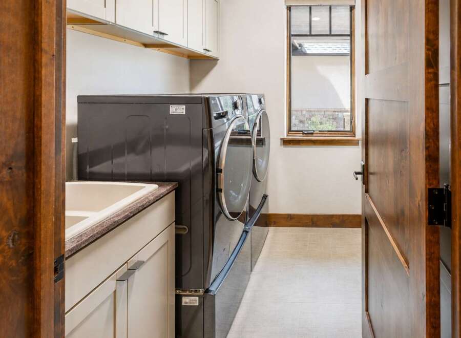 This laundry room features a spacious sink and ample counter space, perfect for folding clothes.