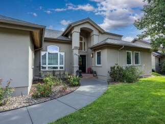 Discover this charming home featuring a welcoming entryway with a grand arched portico and a paved walkway leading to the front door.