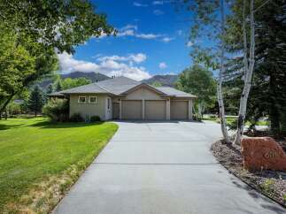 Discover this stunning property featuring a spacious three-car garage and a beautifully manicured lawn, perfect for outdoor enjoyment.
