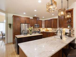Experience luxury in this stunning kitchen featuring rich wood cabinetry and a spacious island with a granite countertop.