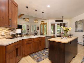 Experience luxury living in this stunning kitchen featuring rich wood cabinetry, elegant marble countertops, and a spacious island perfect for entertaining.