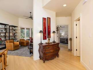 Step into this inviting entryway featuring a charming antique dresser adorned with decorative lamps and artwork.