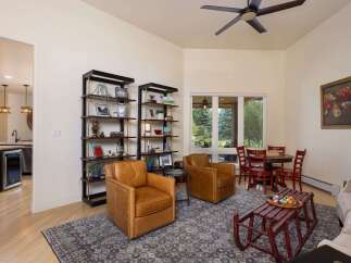 This inviting living space features two plush leather armchairs perfect for relaxation, complemented by elegant shelving units displaying decorative items.