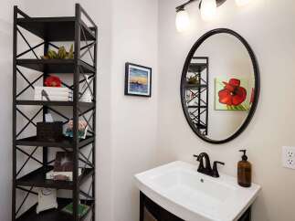 This bathroom features a stylish black metal shelving unit offering ample storage and decorative space.