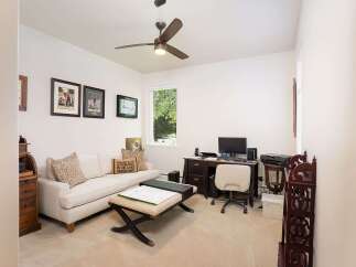 This home office features a comfortable sofa and ottoman, perfect for breaks or informal meetings.