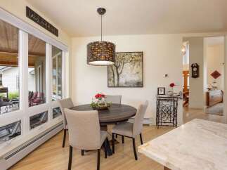 Enjoy meals in this charming dining area, featuring a round wooden table with upholstered chairs perfect for intimate gatherings.