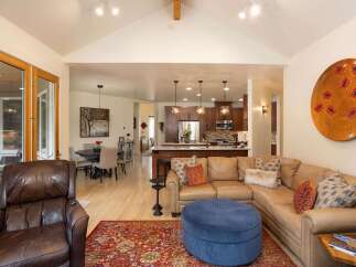 Experience open-concept living in this stunning home, featuring a spacious living area flowing seamlessly into a modern kitchen and dining space.