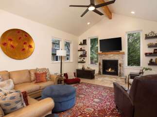 This inviting living room features a cozy fireplace with a stone surround and a wooden mantel, perfect for gathering on cool evenings.