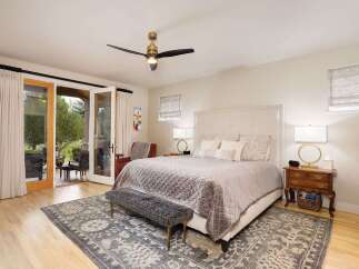 Experience ultimate comfort in this beautifully appointed bedroom, featuring a plush king-sized bed with a tufted headboard and a luxurious quilted comforter.