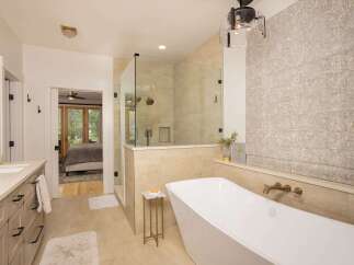 Experience luxury in this stunning bathroom featuring a freestanding soaking tub and a spacious glass-enclosed shower.