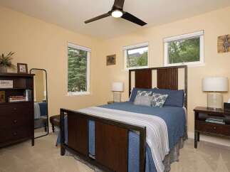 This charming bedroom features a rustic wooden bed frame and a coordinating headboard, complemented by a dark wood dresser and nightstand.