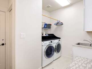 This laundry room features a stacked GE washer and dryer set, perfect for maximizing space.