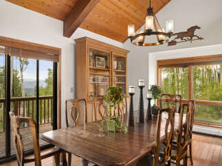 Experience rustic charm in this inviting dining room, featuring a grand wooden table perfect for family gatherings.