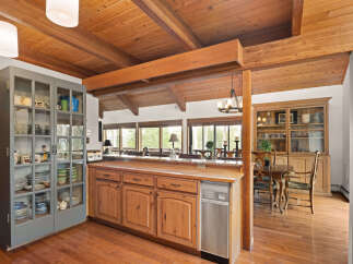 This charming kitchen boasts a rustic aesthetic with its warm wood cabinetry and exposed beam ceiling.