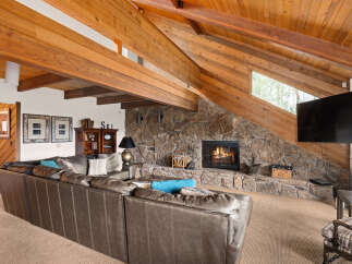 Experience rustic charm in this inviting living room, featuring a magnificent stone fireplace as the centerpiece.