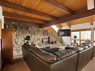 Experience rustic charm in this inviting living room, featuring a magnificent stone fireplace as the centerpiece.