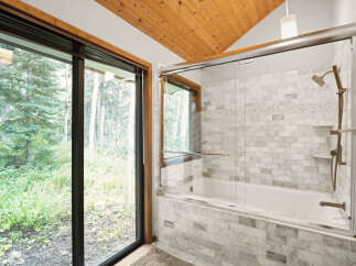 Experience serene living with this stunning bathroom featuring a luxurious bathtub and shower combo, elegantly tiled with marble.