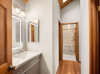 Step into this charming bathroom featuring a sleek vanity with a modern faucet and a well-lit mirror.
