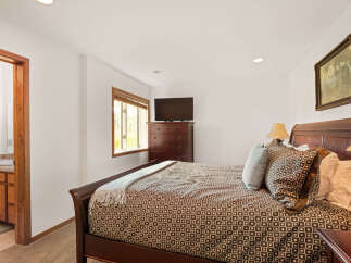This inviting bedroom features a comfortable queen-size bed with a stylish brown and white patterned comforter and plush pillows.