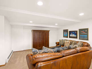 This inviting living space features a plush leather sofa adorned with decorative pillows, perfect for relaxation.