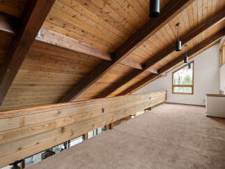 Experience the architectural beauty of this loft space, featuring a stunning vaulted wood-paneled ceiling with exposed beams that create a warm and inviting atmosphere.