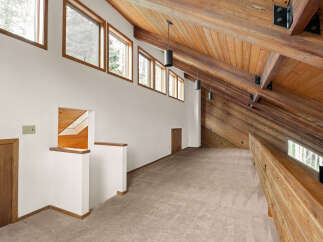 Experience the unique architectural charm of this loft space, featuring a stunning vaulted wood-beamed ceiling and a series of clerestory windows that bathe the area in natural light.