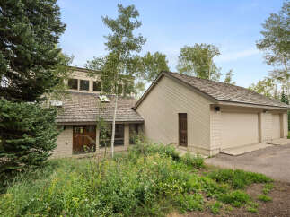 Nestled amidst lush greenery and mature trees, this charming home offers a serene retreat.