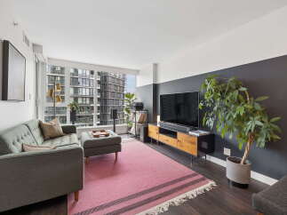 Experience modern city living in this stylish apartment featuring a spacious living area with a large window offering stunning urban views.