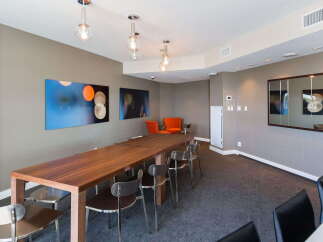 This modern dining area features a long, rich wood table perfect for gatherings, complemented by sleek, contemporary chairs.