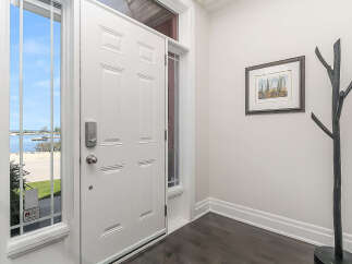 Step into this inviting entryway featuring a bright white door with elegant paneling and a modern smart lock.