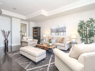 Experience sophisticated living in this elegantly appointed living room, featuring plush seating and a striking coffee table.