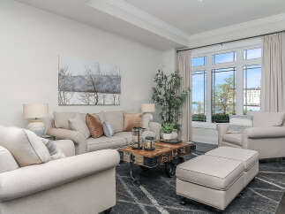 Experience elegant living in this beautifully appointed living room, featuring a plush sectional sofa and comfortable armchairs perfect for relaxation.