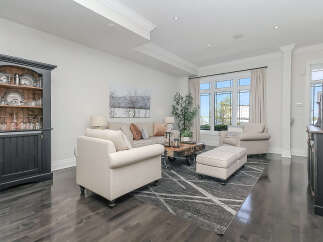 Step into this elegantly appointed living room, featuring a plush sofa and armchair arrangement perfect for relaxation.