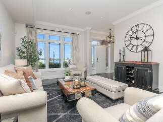 Experience elegant living in this beautifully appointed living room, featuring a large sectional sofa and a unique rustic coffee table.