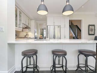 This modern kitchen boasts a sleek white island with a marble countertop, perfect for casual dining or entertaining.