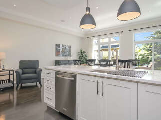 Experience modern living in this stunning kitchen featuring a sleek island with a built-in dishwasher and ample cabinet space.