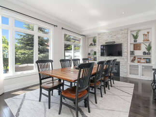 Experience elegant dining in this spacious room featuring a large wooden table surrounded by classic black chairs.
