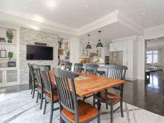 Experience elegant dining in this beautifully appointed space, featuring a rustic wooden table surrounded by stylish chairs.