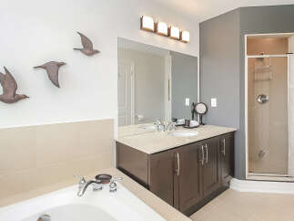 This luxurious bathroom features a spacious soaking tub and a separate glass-enclosed shower, perfect for relaxation.