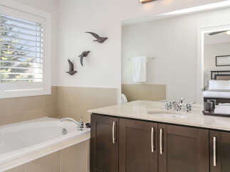 Indulge in relaxation in this luxurious bathroom featuring a deep soaking tub and a spacious vanity with a modern sink and faucet.