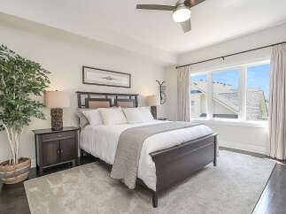 Experience ultimate comfort in this beautifully appointed bedroom, featuring a plush king-size bed with crisp white linens and a stylish upholstered headboard.