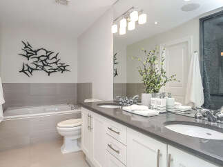 This luxurious bathroom features a spacious bathtub and a modern dual vanity with sleek chrome fixtures.