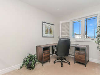 This home office features a modern L-shaped desk with ample storage, perfect for productivity.